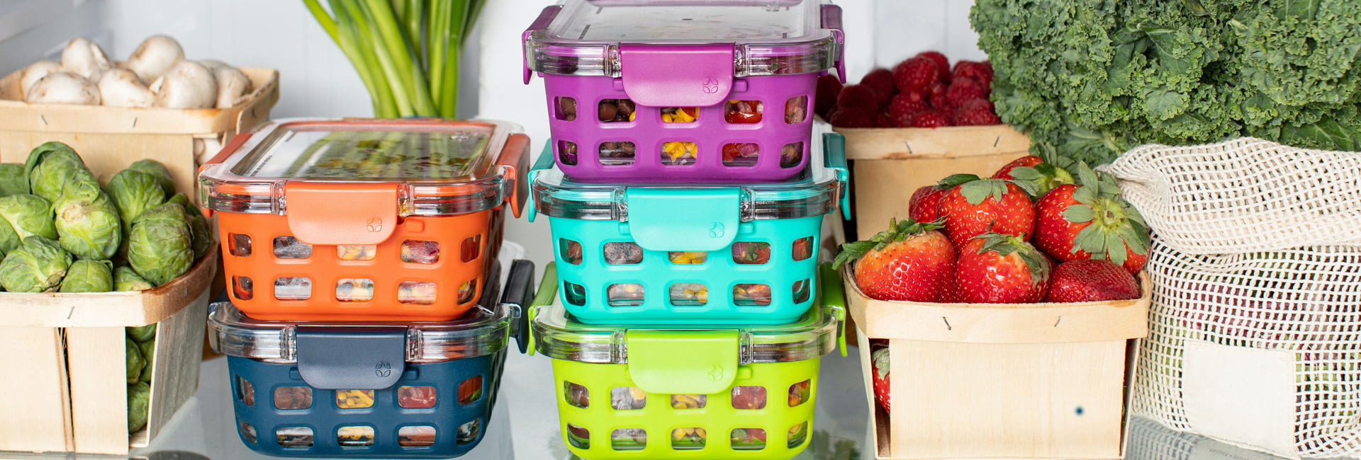 Various food containers containing fresh produce, on a fridge shelf.