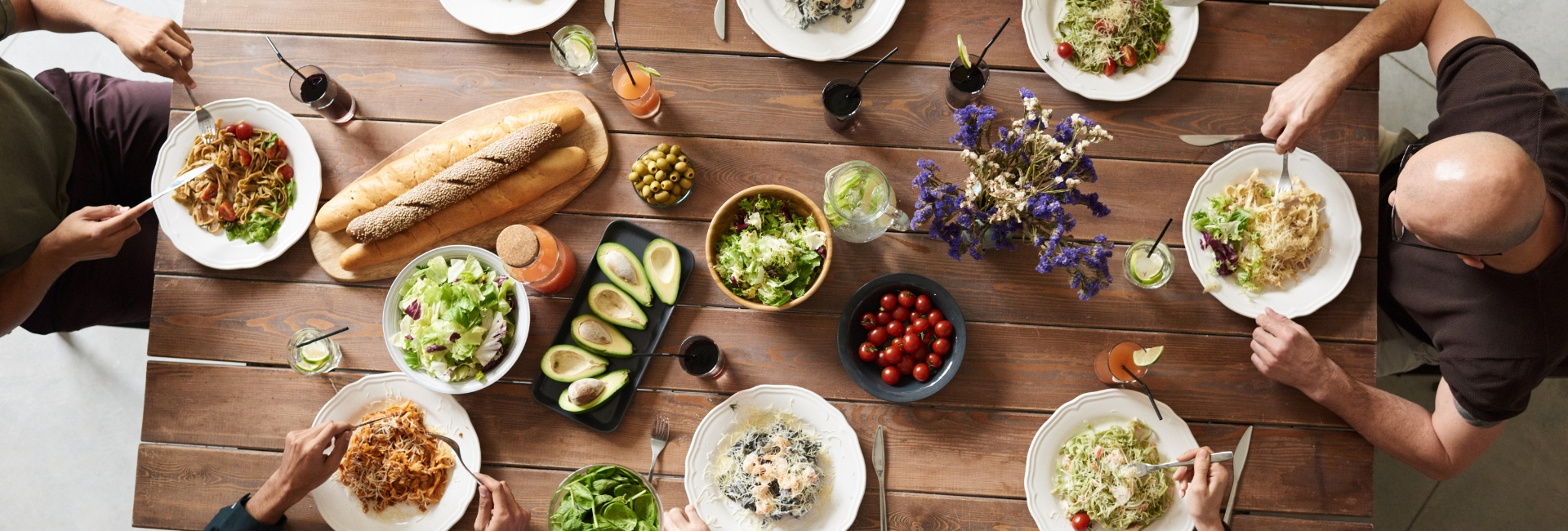 Overhead shot of people at a table eating from a variety of dishes