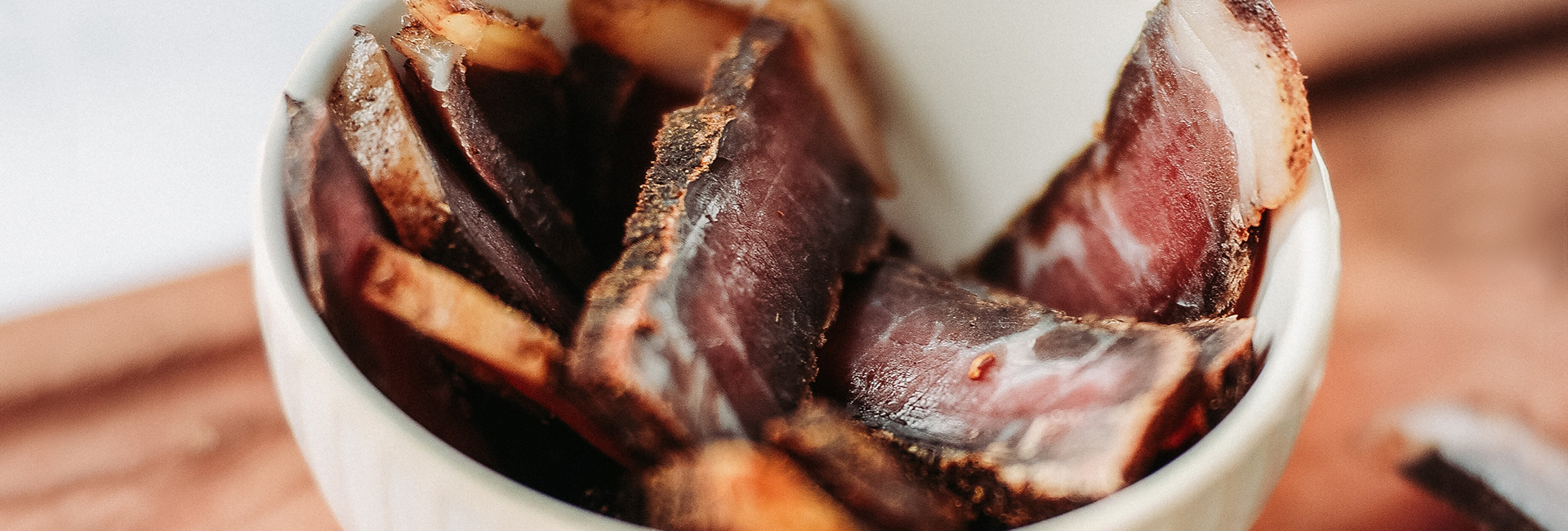 Bowl of Biltong on chopping board.
