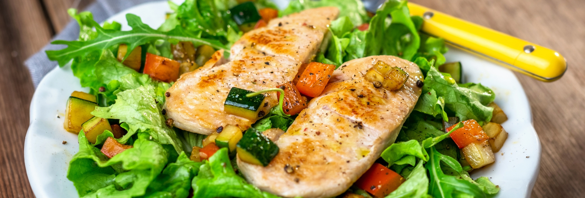 Grilled chicken breasts on a bed of salad