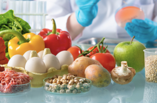 Fresh fruit and meat in the foreground on a table in a chemistry lab