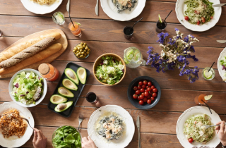 Overhead shot of people at a table eating from a variety of dishes