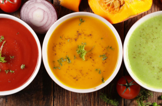 3 Different bowls of soup on a wooden table