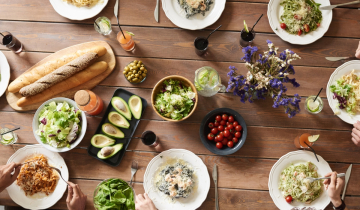 Overhead shot of people at a table eating from a variety of dishes