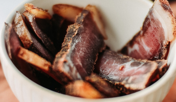 Bowl of Biltong on chopping board.