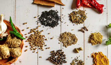Raw curry spices including garlic, ginger, cloves, and chillies.